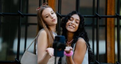 Young Fashionable Girls Taking a Picture with a Smartphone on a Tripod