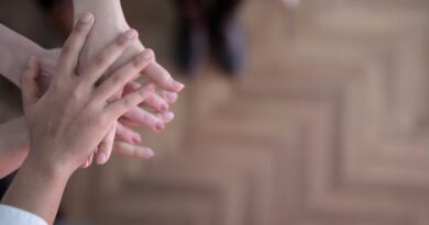 Crop group stacking hands together