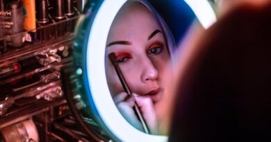 Woman Facing Mirror Applying Eyeshadow