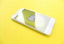 silver iPhone 6 on top of yellow wooden surface