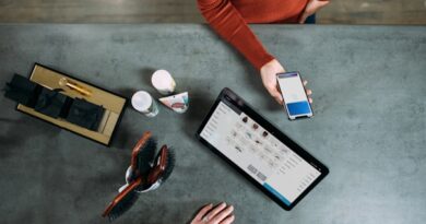 person holding smartphone beside tablet computer